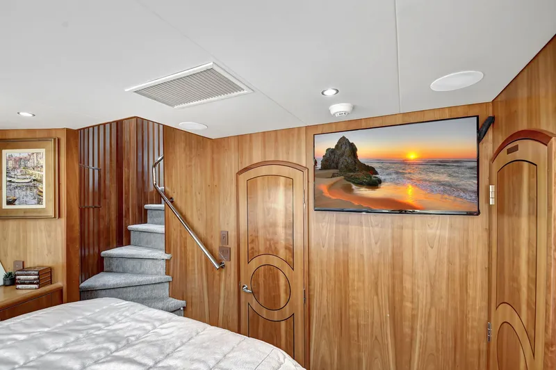 Slide: The Image of Luxurious 2005 Hatteras Semi-Displacement yacht interior with wood paneling and mounted TV. - 28
