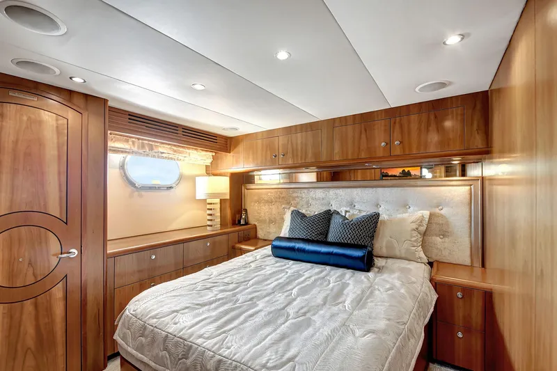 Slide: The Image of Luxurious 2005 Hatteras Semi-Displacement yacht bedroom with elegant wood paneling and cozy bedding. - 33