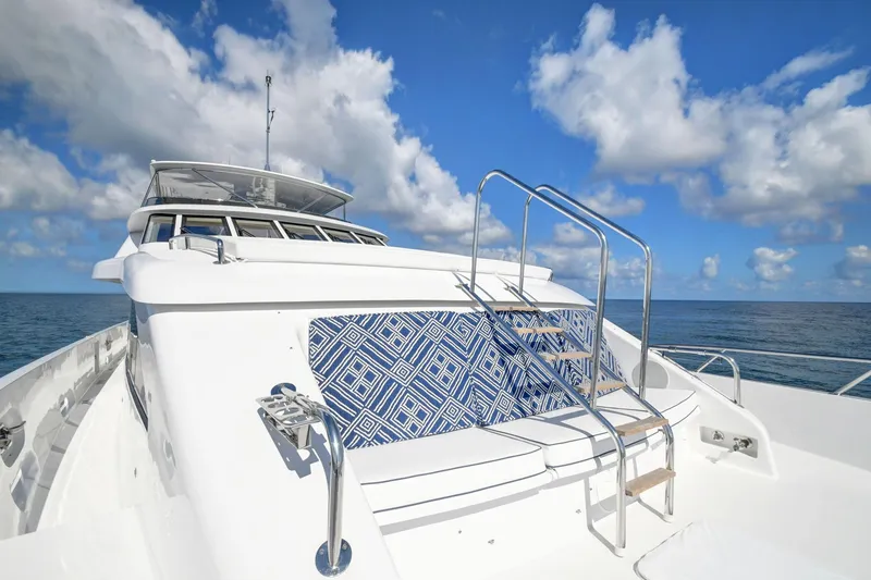 Slide: The Image of Hatteras 2005 Semi-Displacement yacht with blue patterned seating, under a clear sky. - 37