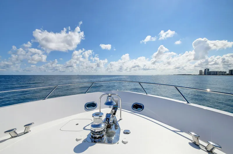 Slide: The Image of Bow view of 2005 Hatteras Semi-Displacement yacht on open sea under clear blue sky. - 38