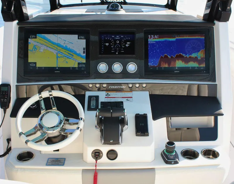 Slide: The Image of 2025 Fountain 38 SCX boat dashboard with navigation screens and controls. - 14