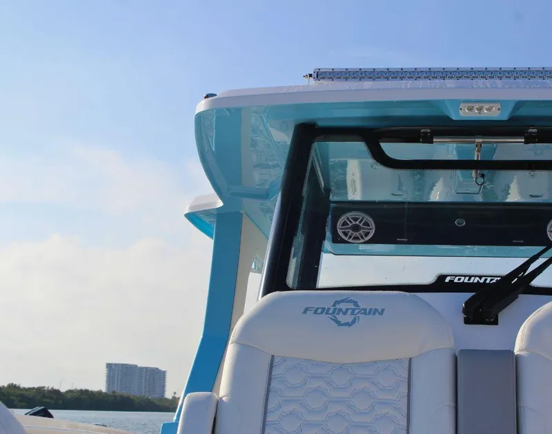 Slide: The Image of 2025 Fountain 38 SCX boat interior with logo, blue sky background. - 28