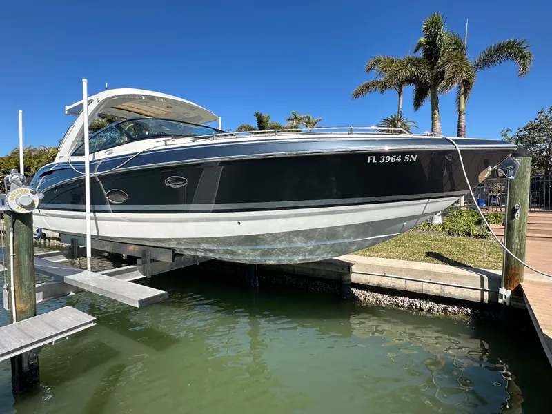 The Image of 2020 Formula 350 Crossover Bowrider OB on lift, docked near palm trees. - 1