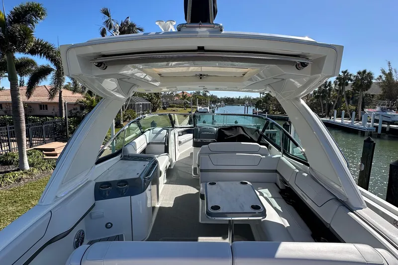Slide: The Image of 2020 Formula 350 Crossover Bowrider OB, spacious interior, docked by a scenic waterfront. - 12