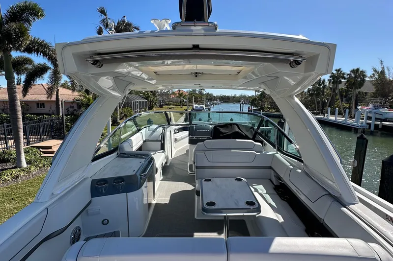 Slide: The Image of 2020 Formula 350 Crossover Bowrider OB, spacious interior, luxury seating, docked by waterfront homes. - 13