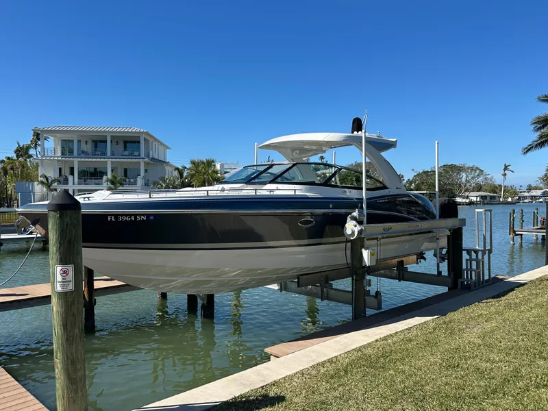 Slide: The Image of 2020 Formula 350 Crossover Bowrider OB on lift by waterfront home. - 3