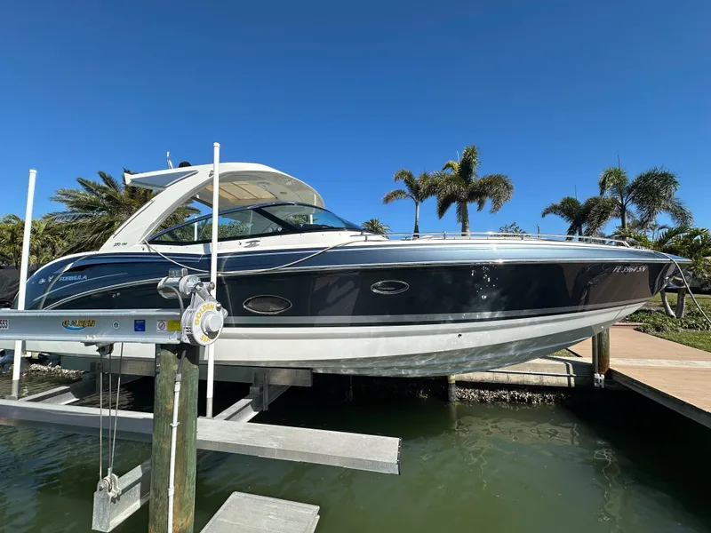 Slide: The Image of 2020 Formula 350 Crossover Bowrider OB on lift, sleek design, palm trees in background. - 6