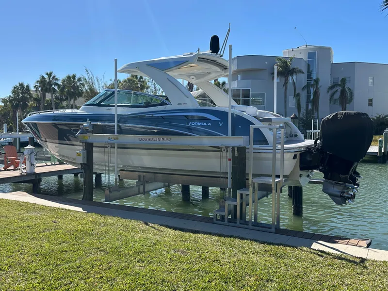 Slide: The Image of 2020 Formula 350 Crossover Bowrider OB on lift by waterfront property. - 8