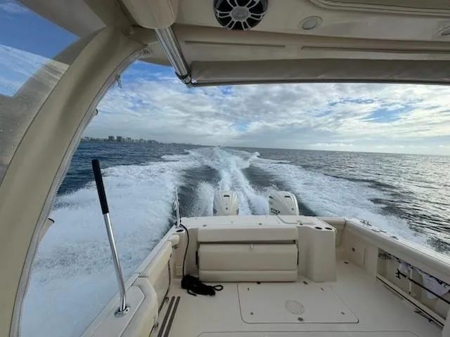 Slide: The Image of 2024 Grady-White Freedom 335 boat docked on a calm waterfront. - 10