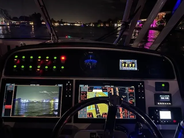 Slide: The Image of 2024 Grady-White Freedom 335 boat cockpit with navigation screens, steering wheel, and ocean view. - 12