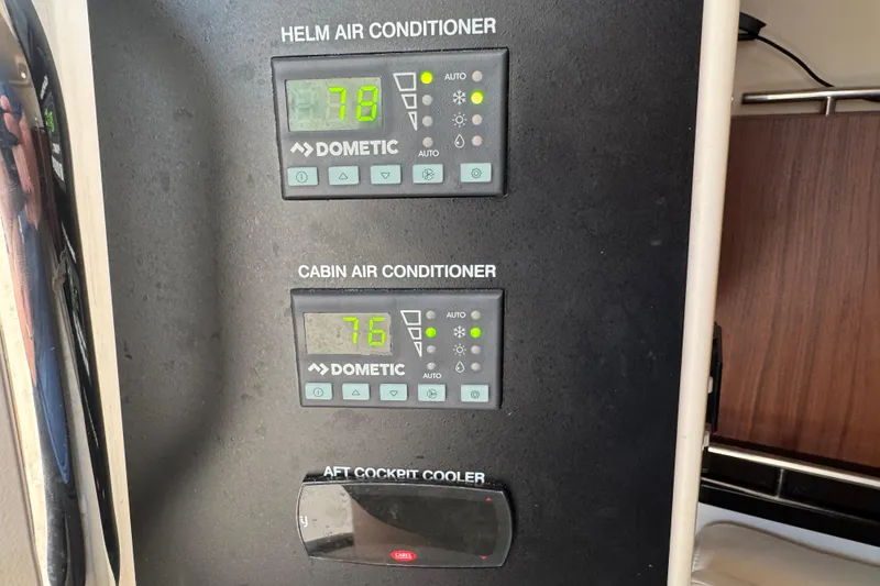 Slide: The Image of 2024 Grady-White Freedom 335 boat interior with seating and table, docked by a scenic waterfront. - 21