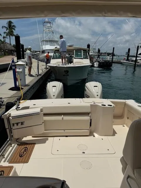 Slide: The Image of 2024 Grady-White Freedom 335 boat with luxurious seating, docked by a scenic waterfront. - 6