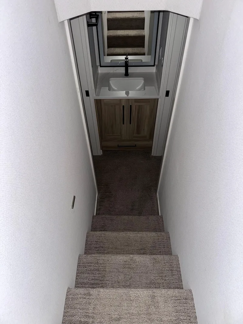 Slide: The Image of Narrow staircase leading to a compact bathroom with a sink, in Adonia Cosmos Trip #11, 2024. - 13
