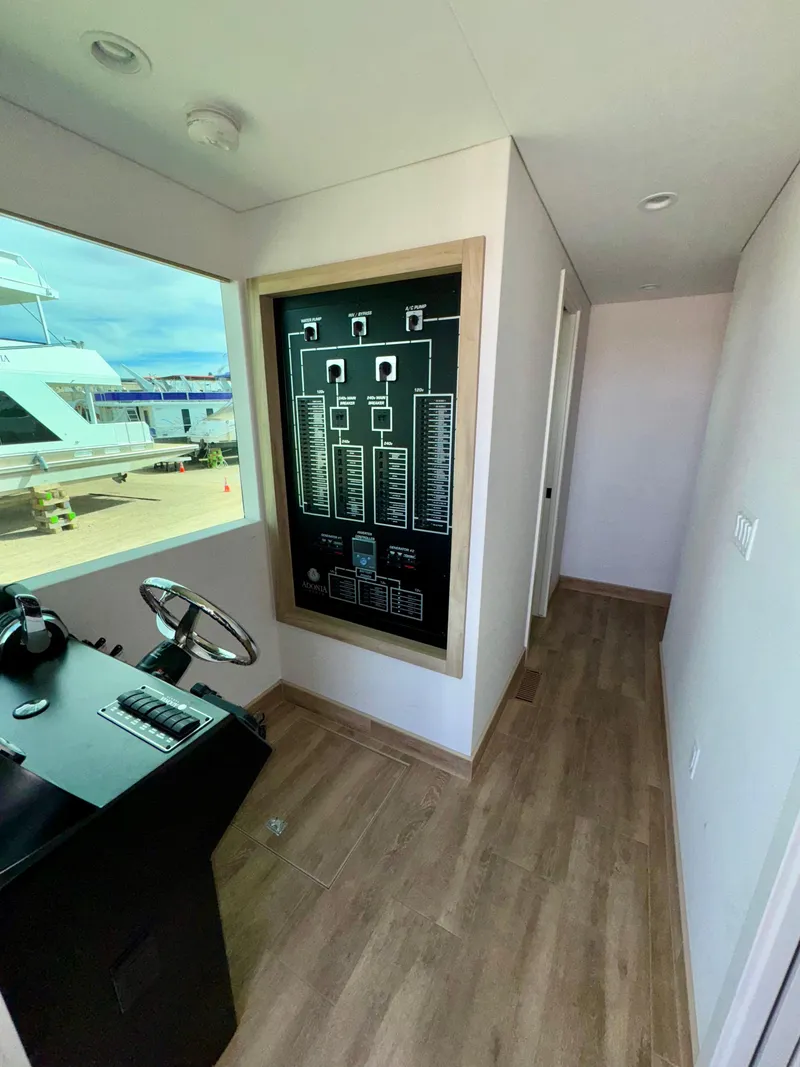 Slide: The Image of Modern yacht interior with control panel, wooden flooring, and large window. Adonia Cosmos Trip #11, 2024. - 20