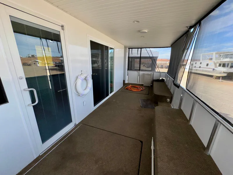 Slide: The Image of Covered deck area on Adonia Cosmos Trip #11, 2024 model, with glass doors and seating. - 21