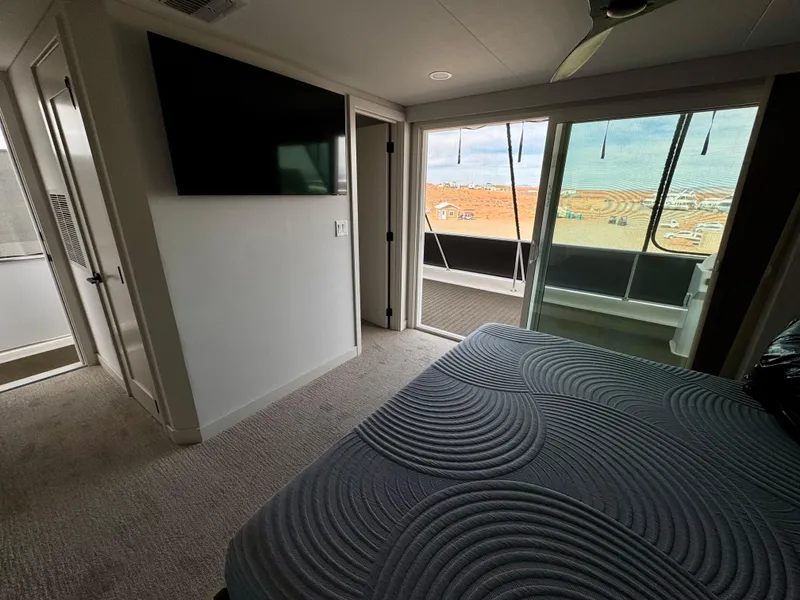 Slide: The Image of Modern bedroom interior with ocean view, featuring a TV and stylish bedding. Adonia Cosmos Trip #11, 2024. - 24
