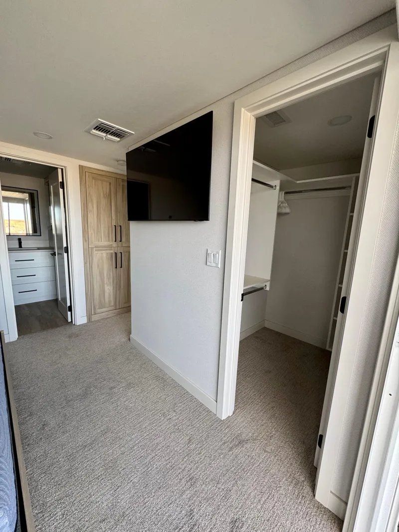 Slide: The Image of Modern bedroom with TV, walk-in closet, and wooden cabinetry in Adonia Cosmos Trip #11, 2024 model. - 26