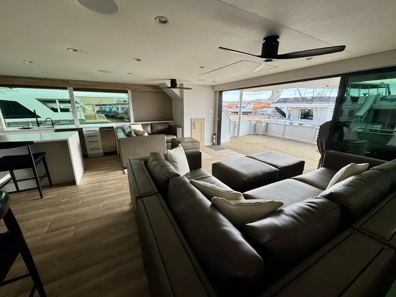 Slide: The Image of Luxurious yacht interior with modern furnishings, spacious seating, and large windows. Adonia Cosmos Trip #11, 2024. - 6