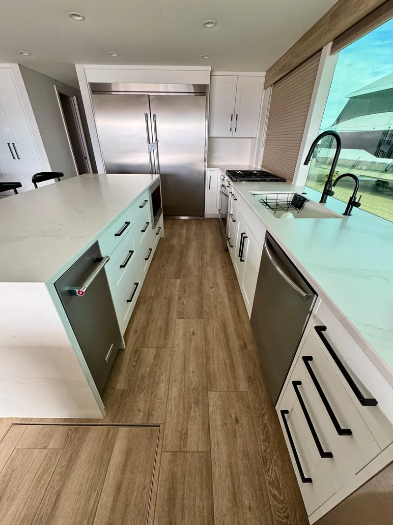 Slide: The Image of Modern kitchen in Adonia Cosmos Trip #11, 2024, with sleek appliances and wooden flooring. - 8