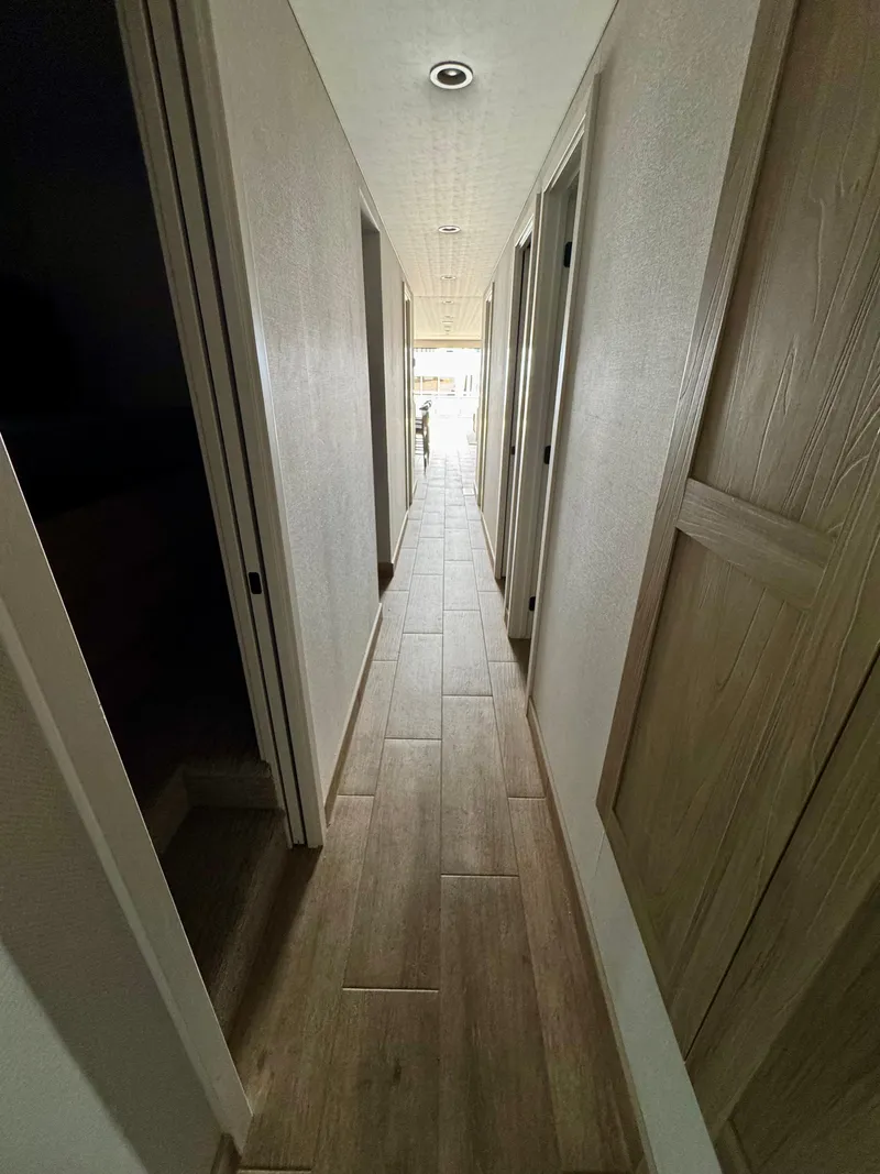 Slide: The Image of Narrow hallway with wooden doors and flooring in Adonia Cosmos Trip #11, 2024 model. - 9