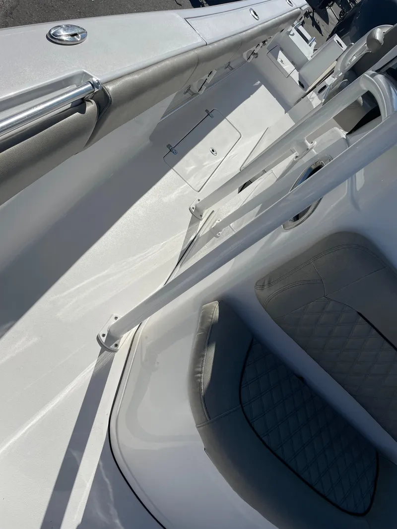 Slide: The Image of 2021 Sportsman Open 282 Center Console boat interior with white seating and railings. - 17