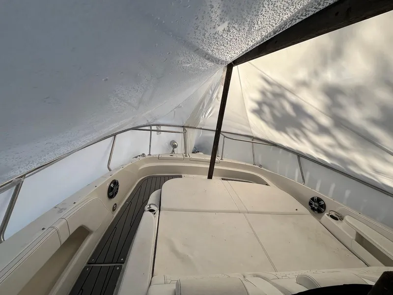 Slide: The Image of 2020 Sea Ray Sundancer 320 under protective cover, showcasing deck and seating area. - 30