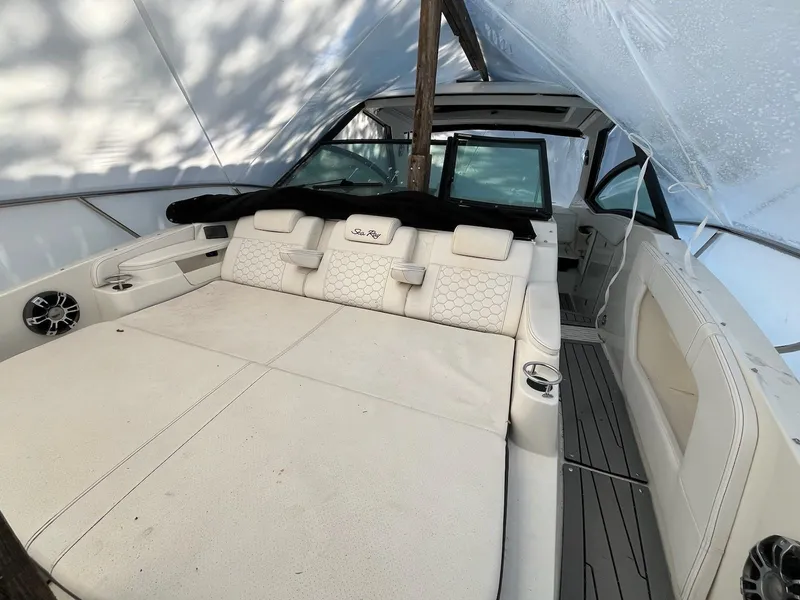 Slide: The Image of 2020 Sea Ray Sundancer 320 boat interior with spacious seating under a protective cover. - 32