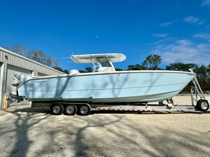 Slide: The Image of 2020 Invincible 37 Catamaran on trailer, parked outdoors under clear blue sky. - 2