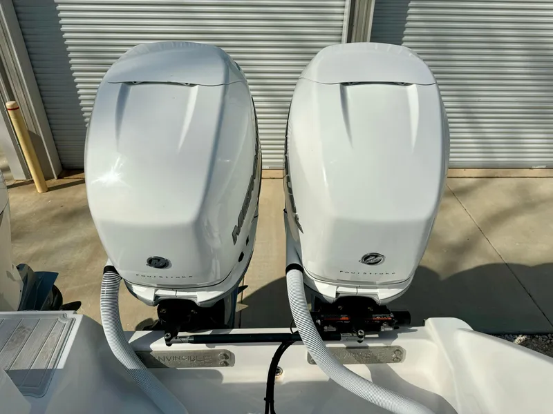Slide: The Image of Twin outboard engines on a 2020 Invincible 37 Catamaran, parked near a garage. - 25