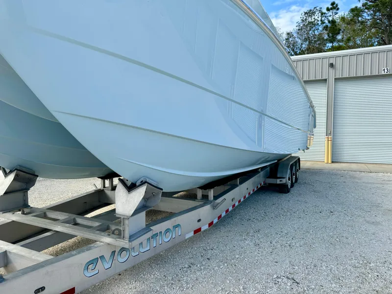 Slide: The Image of 2020 Invincible 37 Catamaran on trailer, parked outside a warehouse. - 34