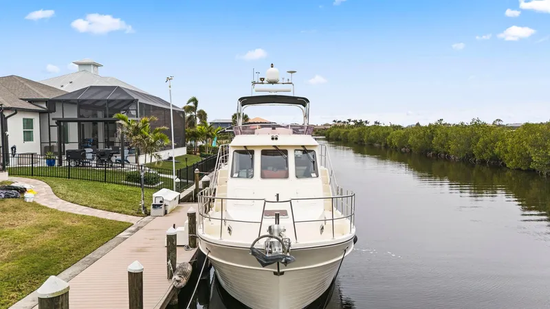 Slide: The Image of 2008 North Pacific 43 Pilothouse yacht docked by a waterfront home. - 43