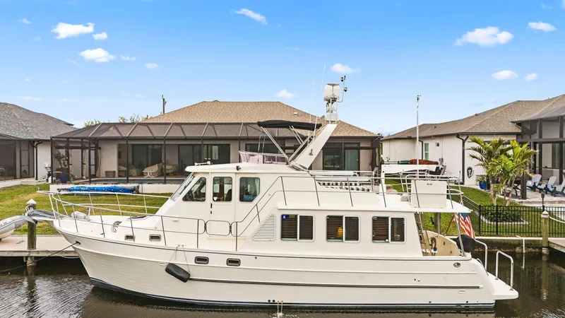 Slide: The Image of 2008 North Pacific 43 Pilothouse yacht docked by waterfront homes. - 44