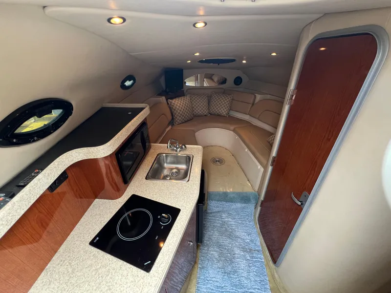 Slide: The Image of 2008 Regal 2665 boat interior with kitchenette, sink, and seating area. - 14