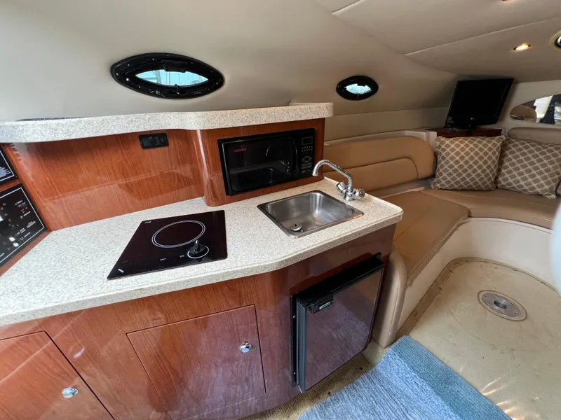 Slide: The Image of 2008 Regal 2665 yacht interior with kitchenette, sink, and seating area. - 17