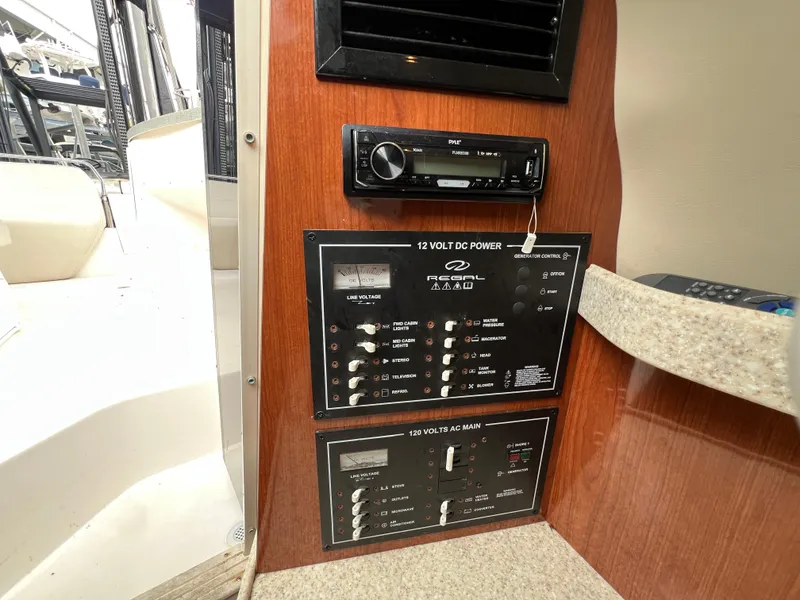 Slide: The Image of Control panel of a 2008 Regal 2665 boat, featuring power switches and audio system. - 19