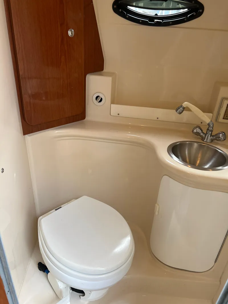 Slide: The Image of 2008 Regal 2665 boat bathroom with toilet, sink, and wooden cabinet. - 20