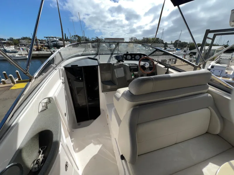 Slide: The Image of 2008 Regal 2665 boat interior with helm, seating, and marina view. - 7