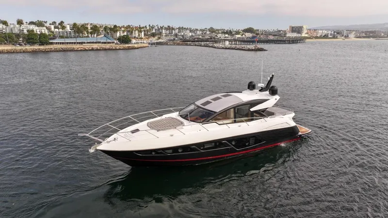 Slide: The Image of 2019 Sunseeker Predator 57 yacht cruising in a scenic coastal area. - 9