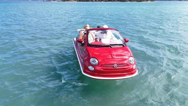 Slide: The Image of Red 2025 Car Off-shore Fiat 500 Classic floating on water, resembling a boat. - 5