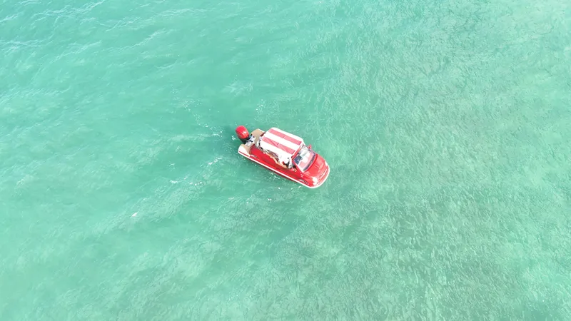 Slide: The Image of Aerial view of a red Fiat 500 Classic boat on turquoise water, 2025 model. - 9