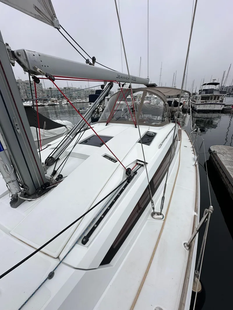 Slide: The Image of 2015 Jeanneau 41DS sailboat docked in marina, showcasing deck and rigging. - 24
