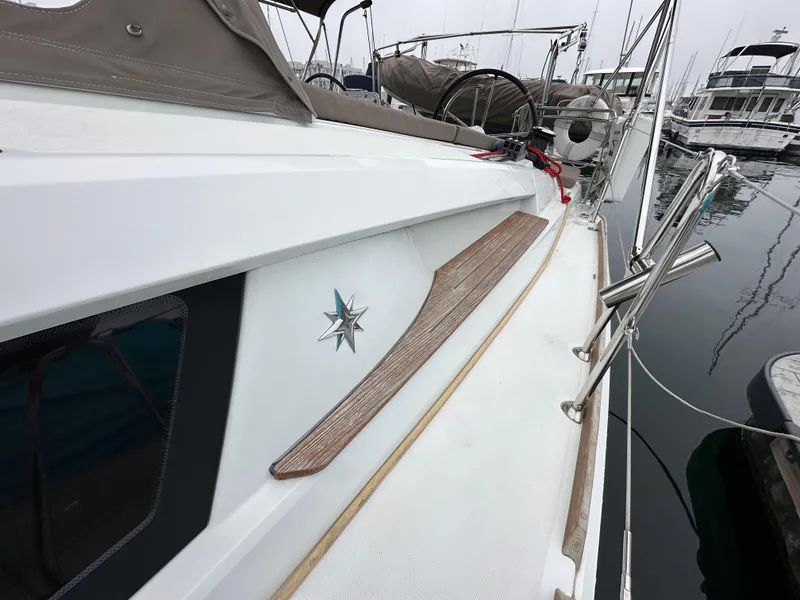 Slide: The Image of 2015 Jeanneau 41DS sailboat deck with wood accents, docked in a marina. - 26