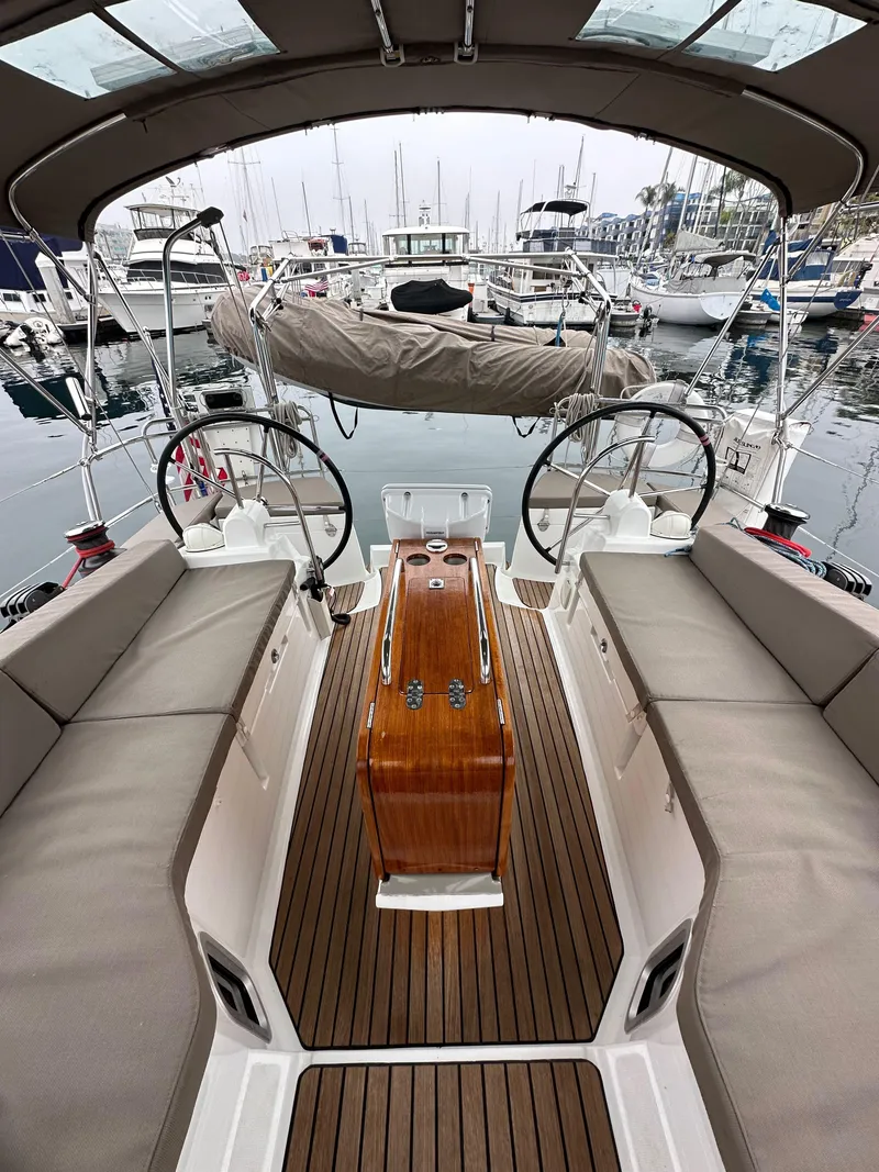 Slide: The Image of 2015 Jeanneau 41DS sailboat cockpit with dual steering wheels, docked in a marina. - 31