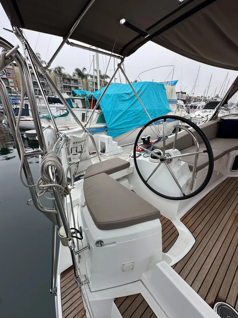 Slide: The Image of 2015 Jeanneau 41DS sailboat cockpit with dual helm, docked in a marina. - 34