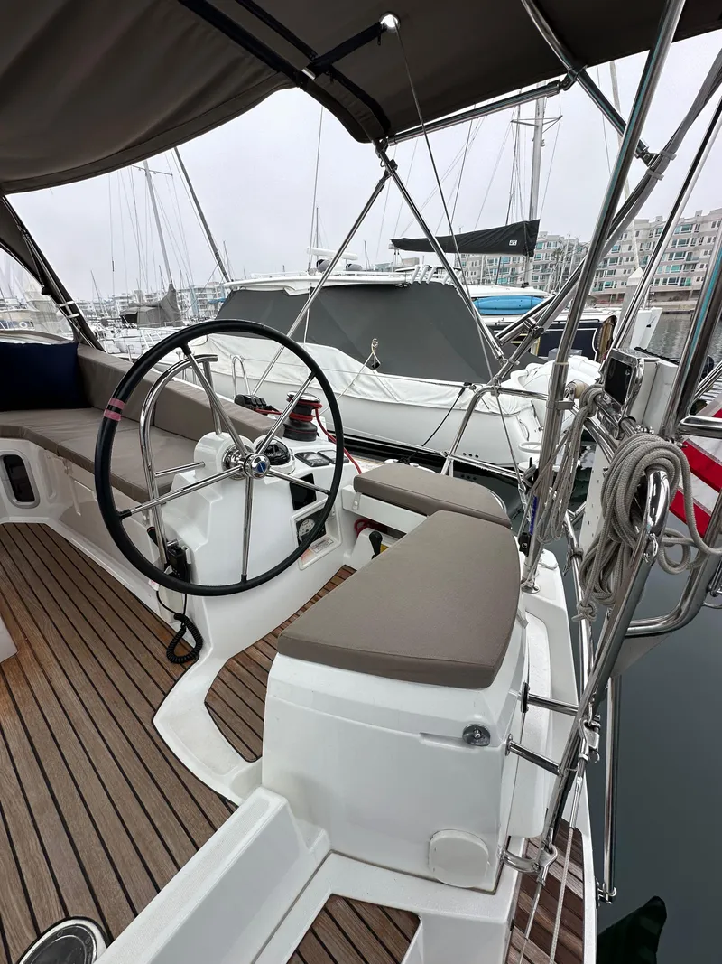 Slide: The Image of 2015 Jeanneau 41DS sailboat cockpit with steering wheel and seating, docked at marina. - 36
