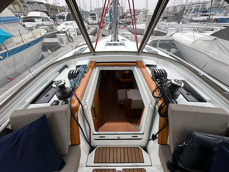 Slide: The Image of 2015 Jeanneau 41DS sailboat cockpit with marina view, showcasing winches and teak flooring. - 47