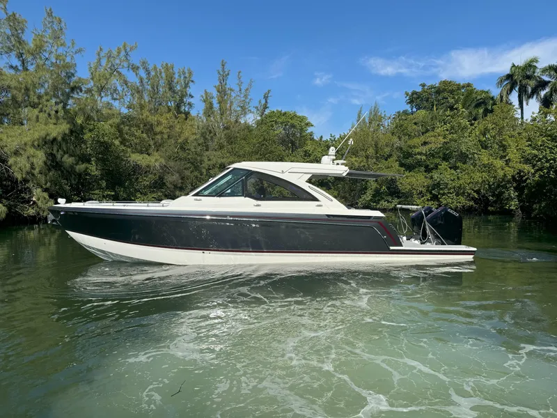 Slide: The Image of 2022 Formula 380 Super Sport Crossover OB cruising on a serene waterway. - 2
