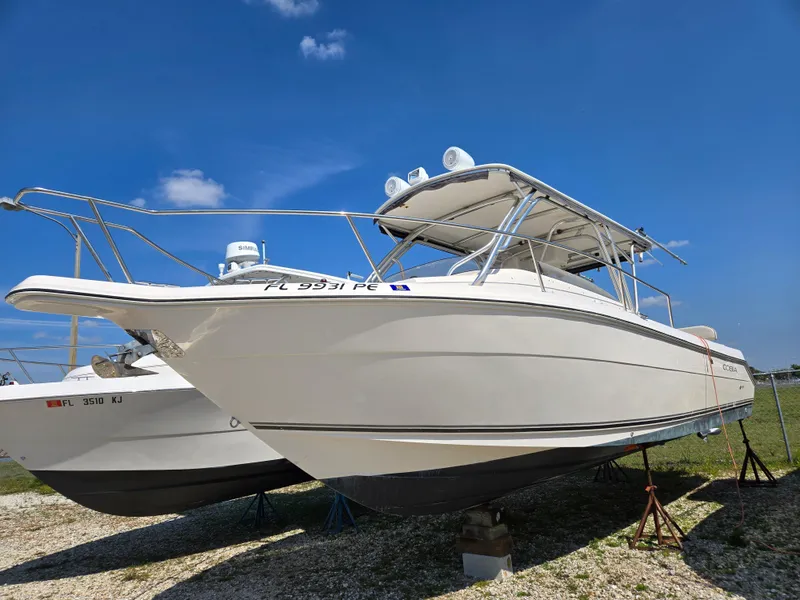 Slide: The Image of 2008 Cobia 316 Sport Cabin boat on display under clear blue sky. - 0