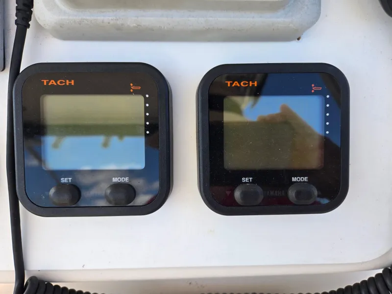 Slide: The Image of Digital tachometers on a 2008 Cobia 316 Sport Cabin boat dashboard. - 12