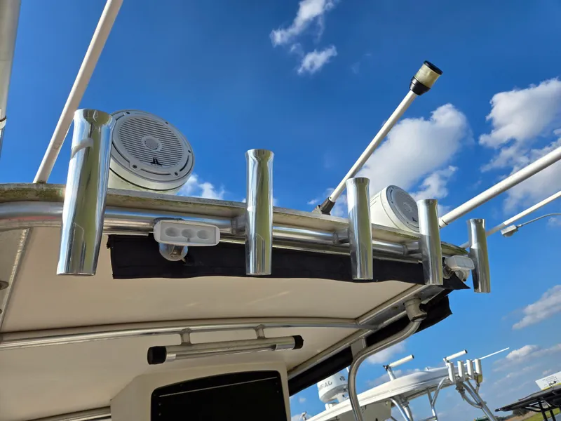 Slide: The Image of 2008 Cobia 316 Sport Cabin boat with rod holders and speakers under a clear blue sky. - 15